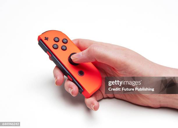 Detail of a woman's hand holding a red Nintendo Switch Joy-Con controller, taken on February 22, 2017.