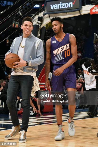 Devin Booker assists Derrick Jones Jr. #10 of the Phoenix Suns dunks the ball during the Verizon Slam Dunk Contest on State Farm All-Star Saturday...