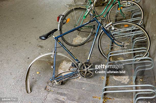 Kaputtes Fahrrad im Fahrradständer, Symbol für Pech, Verfall, Vergänglichkeit