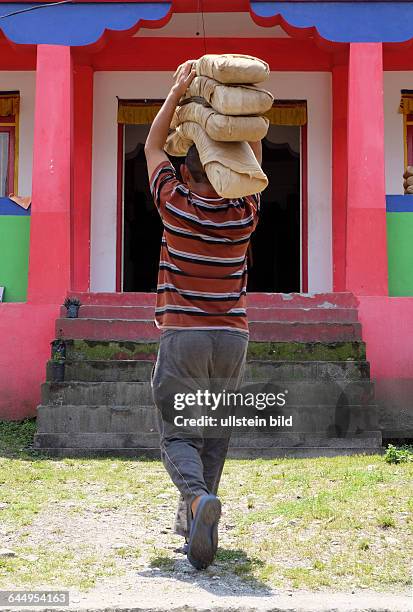 Tempelverwalter Topden Lepcha bringt die gereinigten heiligen Gebetsbücher des buddhistischen Tempels von Singhik in Vorbereitung auf den...