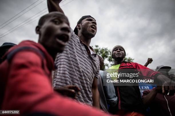 Nigerians gesture as they face-off with a group of South Africans during a stand-off in the center of Pretoria on February 24, 2017. - South African...