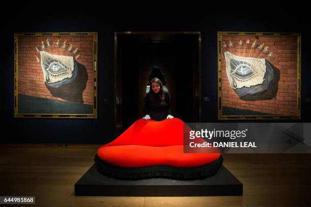 An employee poses with an artwork by Spanish artist Salvador Dali, entitled "Mae West Lips Sofa", with an estimated price of 400,000-600,000 GBP , in...