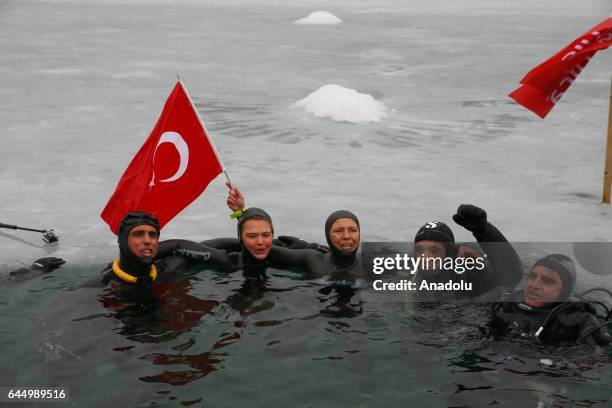 Turkish free diver Derya Can Gocen poses for a photo with her husband Tayfun Gocen and her trainer Adnan Yanbay as she holds a Turkish flag after...