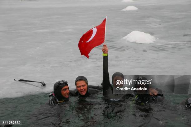 Turkish free diver Derya Can Gocen poses for a photo with her husband Tayfun Gocen and her trainer Adnan Yanbay as she holds a Turkish flag after...