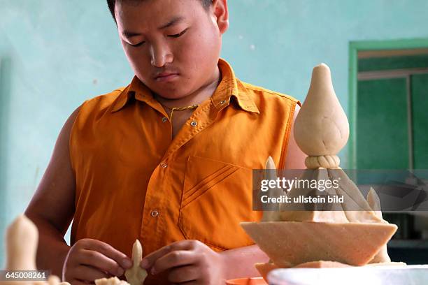 Novizen des buddhistischen Tempels von Singhik bei der Herstellung von Torma, verschieden geformten Opferkuchen aus Teig und gefärbter Butter,...