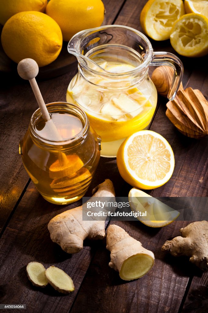Preparing lemon infused water with honey and ginger