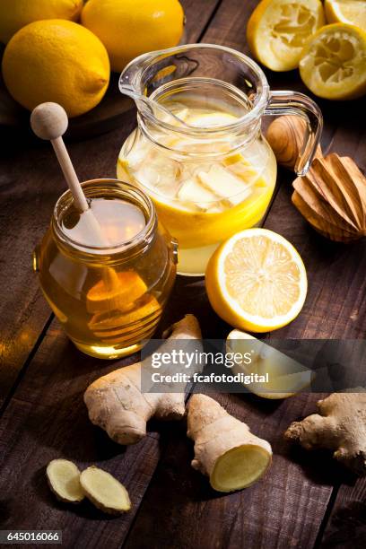 preparing lemon infused water with honey and ginger - honey jar stock pictures, royalty-free photos & images