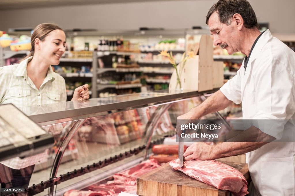 精肉店で肉を買う女