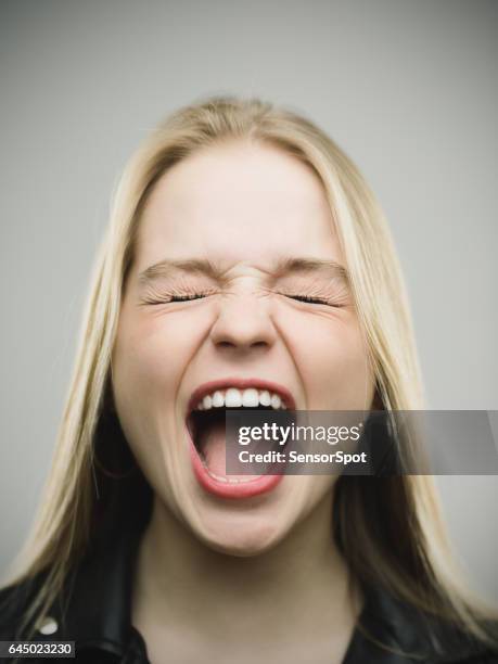 mujer emocionada gritando contra el fondo gris - boca abierta fotografías e imágenes de stock
