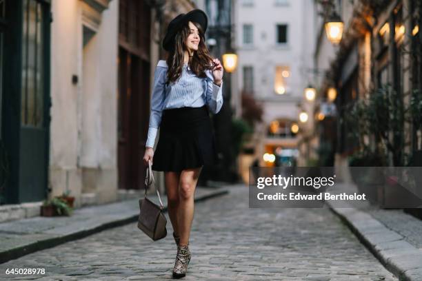 Sarah Benziane, fashion and life style blogger, wears a black hat, a Newlook blue striped top, a Cache Cache black skirt, Newlook snake print boots,...