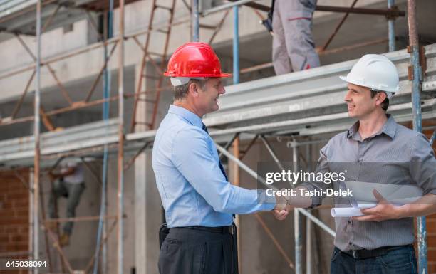 handshake on construction site - roll shirt stock pictures, royalty-free photos & images