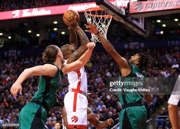 Tucker of the Toronto Raptors shoots the ball as Kelly Olynyk and James Young of the Boston Celtics defend during the first half of an NBA game at...