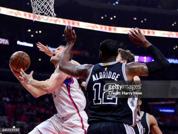 Blake Griffin of the LA Clippers scores on a layup past LaMarcus Aldridge and Pau Gasol of the San Antonio Spurs during the first half at Staples...