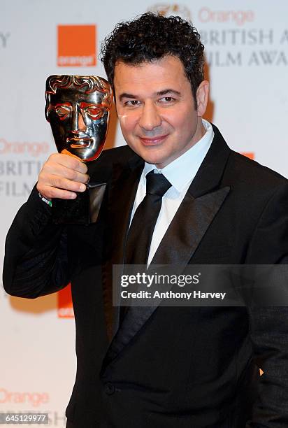 Composer Ludovic Bource poses in the press room with the Best Music award for 'The Artist' during 2012 Orange British Academy Film Awards at The...