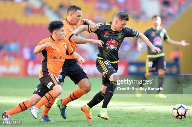 Shane Smeltz of the Phoenix is pressured by the defence of Jade North of the Roar during the round 21 A-League match between the Brisbane Roar and...