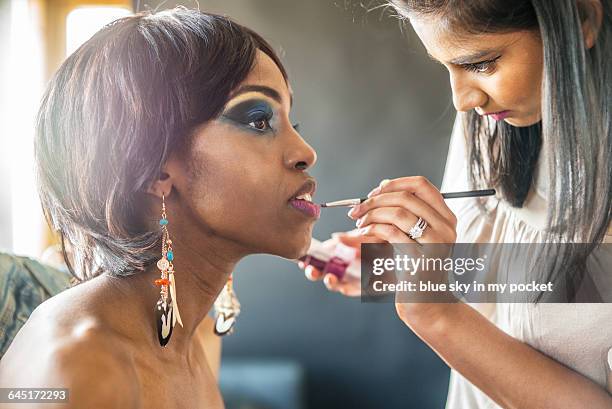 a make-up artist painting lips - konturstift stock-fotos und bilder