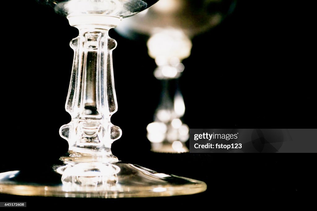 Close up view of crystal stemware glasses on black.