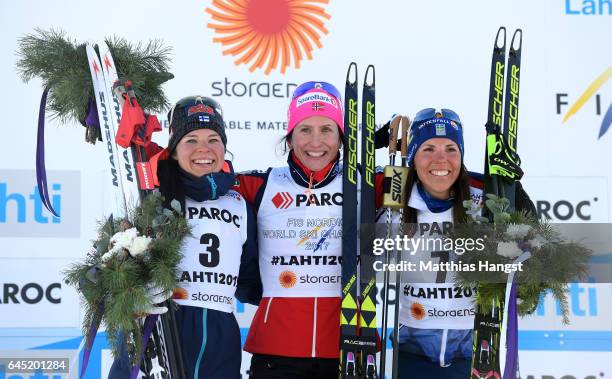 Krista Parmakoski of Finland , Marit Bjoergen of Norway and Charlotte Kalla of Sweden pose during during the flower ceromeny after the Women's Cross...