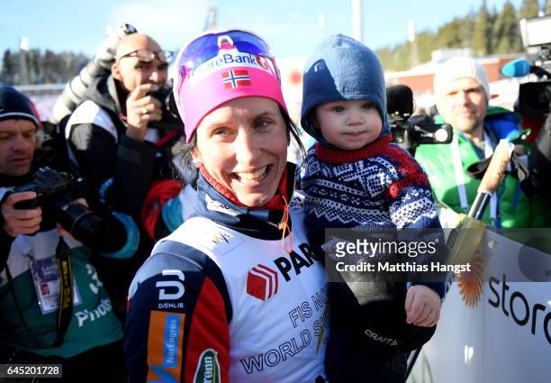 Marit Bjoergen of Norway celebrates her gold medal with her child after the Women's Cross Country Skiathlon during the FIS Nordic World Ski...