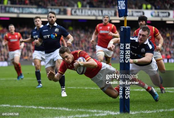 Liam Williams of Wales dives past Stuart Hogg of Scotland to score the opening try during the RBS Six Nations match between Scotland and Wales at...