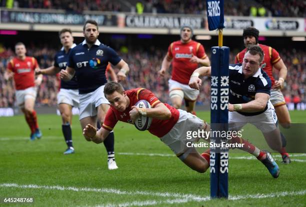 Liam Williams of Wales dives past Stuart Hogg of Scotland to score the opening try during the RBS Six Nations match between Scotland and Wales at...
