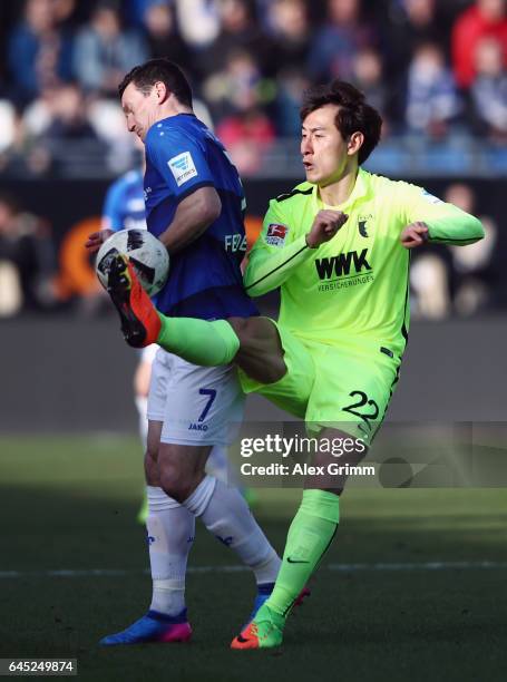 Dong-Won Ji of Augsburg is challenged by Artem Fedetskiy of Darmstadt during the Bundesliga match between SV Darmstadt 98 and FC Augsburg at...