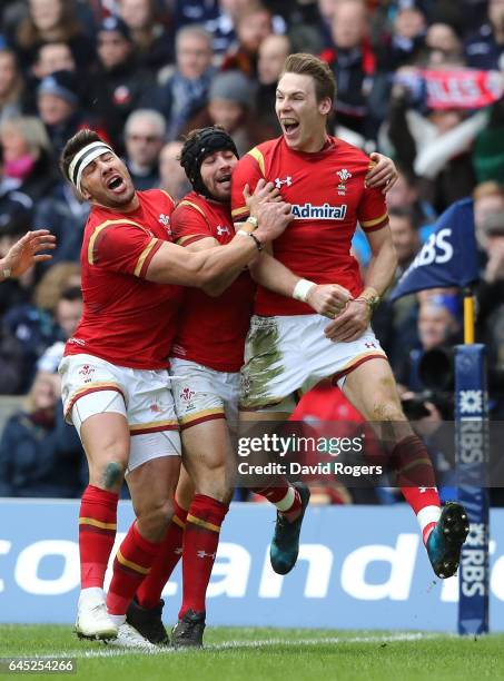 Liam Williams of Wales celebrates with teammates Leigh Halfpenny and Rhys Webb after scoring the opening try during the RBS Six Nations match between...