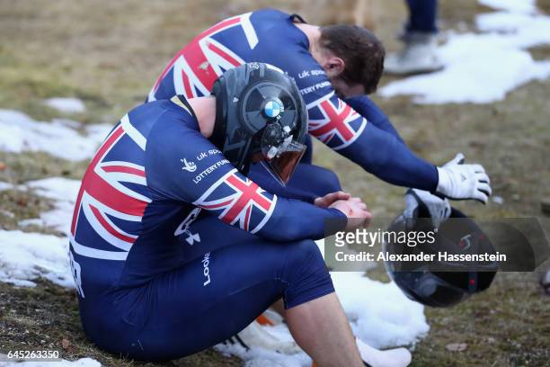 Pilot Bradley Hall of Great Britain reacts with Bruce Tasker after crashing with her team mates Joel Fearon and Gregory Cackett at the second run of...