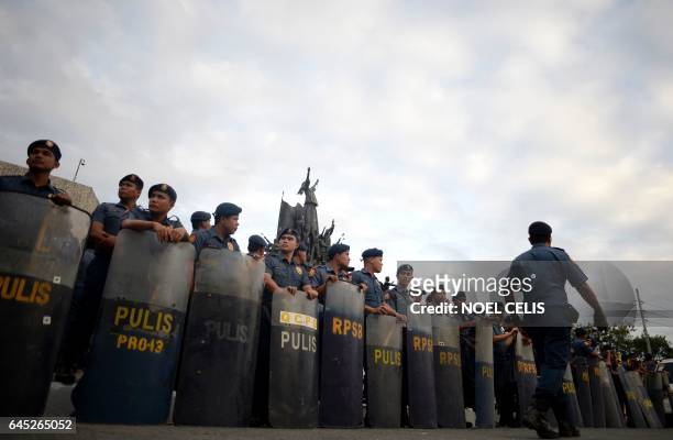Policemen stand in formation during the 31st anniversary of the EDSA People Power Revolution at the People Power Monument in Manila on February 25,...