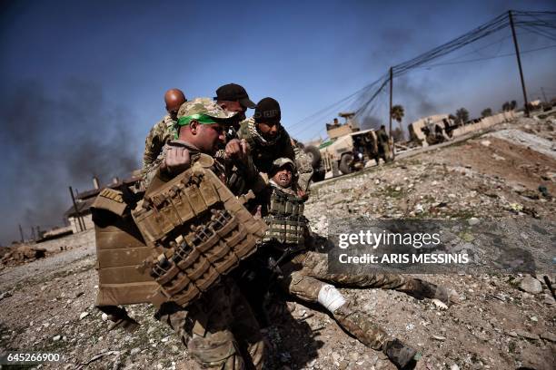 Members of Iraq's elite Rapid Response Division carry a wounded comrade in the northern city of Mosul, as Iraqi forces continue the offensive to...