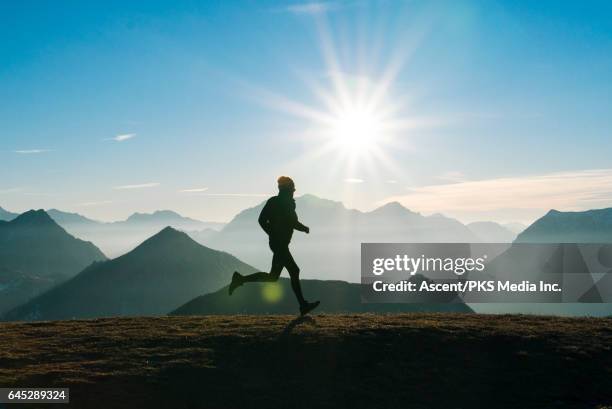 trail runner strides across mountain summit, sunrise - back lit runner stock pictures, royalty-free photos & images