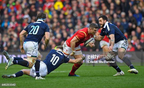 Scott Williams of Wales is tackled by Finn Russell and Alex Dunbar of Scotland during the RBS Six Nations match between Scotland and Wales at...