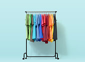 Mobile rack with color clothes on light blue background