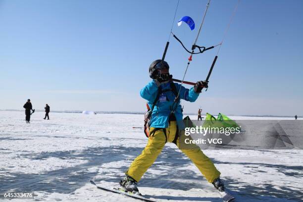 Man flies a kite during the second "Lianhuan Lake Cup" Kite Competition at Lianhuan Lake Hot Spring Resort of Duerbote County on February 25, 2017 in...