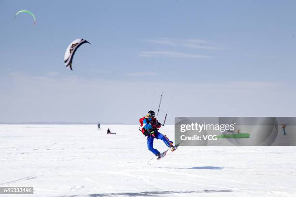 Man flies a kite during the second "Lianhuan Lake Cup" Kite Competition at Lianhuan Lake Hot Spring Resort of Duerbote County on February 25, 2017 in...