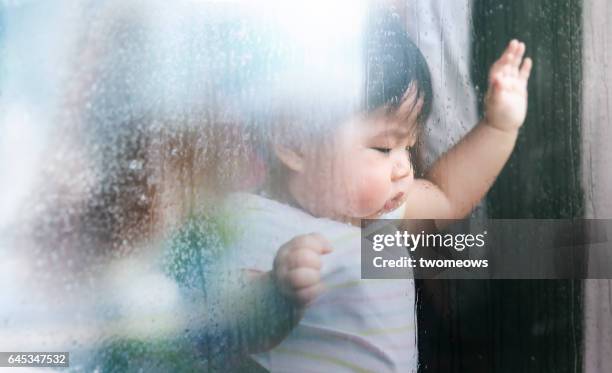 asian baby looking sad in rainy day. - baby shower - fotografias e filmes do acervo