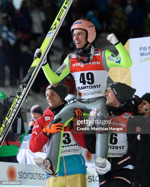 Stefan Kraft of Austria celebrates with his teammates Manuel Fettner of Austria and Gregor Schlierenzauer of Austria after his final jump in the...