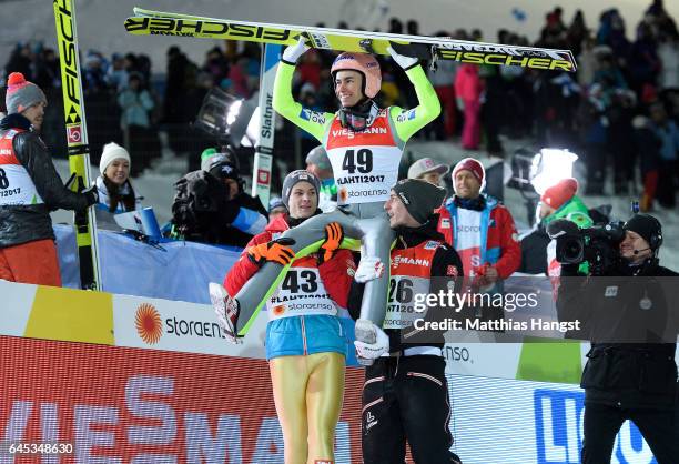 Stefan Kraft of Austria celebrates with his teammates Manuel Fettner of Austria and Gregor Schlierenzauer of Austria after his final jump in the...