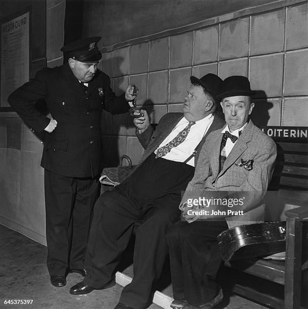 Comedy duo Stan Laurel and Oliver Hardy are arrested for loitering at a railway station in the sketch 'A Spot Of Trouble', performed on stage during...