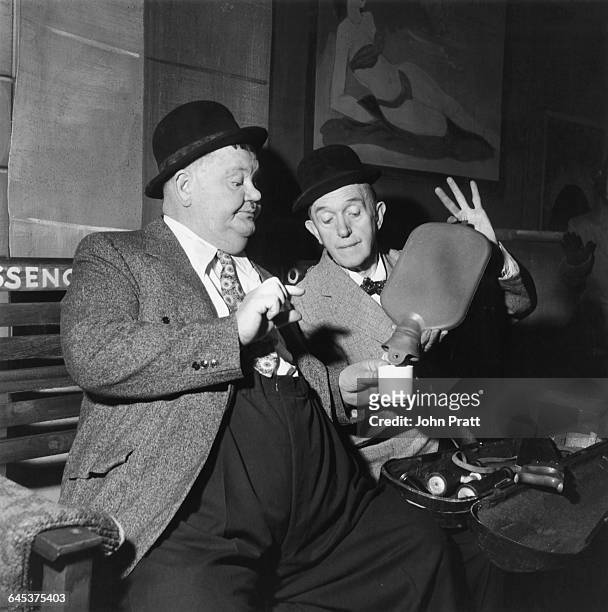 Comedy duo Stan Laurel and Oliver Hardy share an impromptu cup of coffee at a railway station in the sketch 'A Spot Of Trouble', performed on stage...