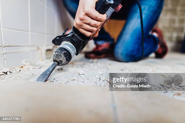 woman removing old tiles. - equipamento de construção - fotografias e filmes do acervo