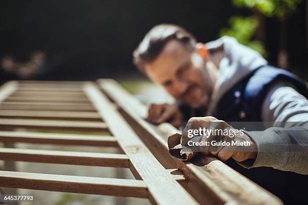 man grinding an old handrail. - wood accuracy stock pictures, royalty-free photos & images