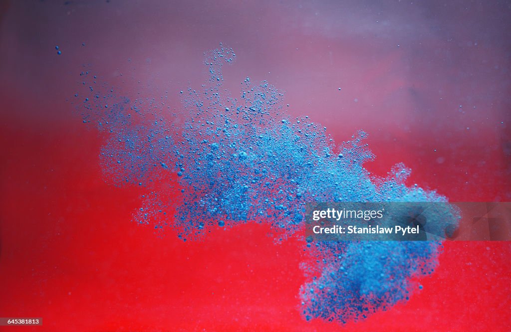 Blue ink cloud on red background