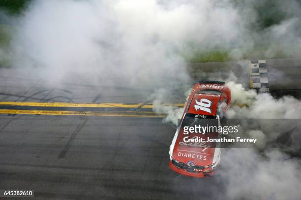 Ryan Reed, driver of the Lilly Diabetes Ford, celebrates with a burnout after winning the NASCAR XFINITY Series PowerShares QQQ 300 at Daytona...