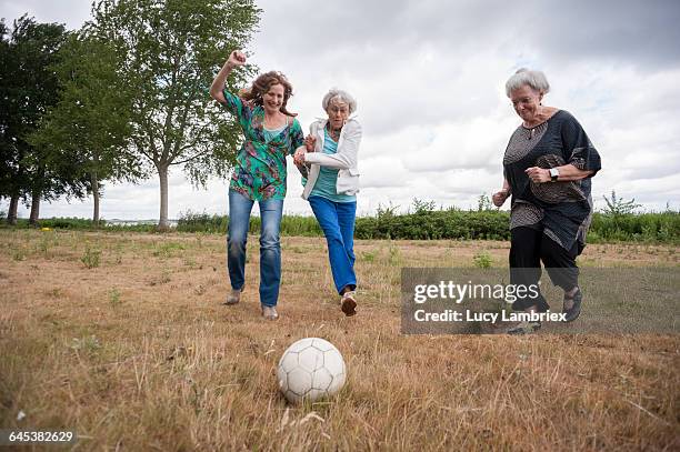 three women playing soccer outdoors - netherlands football stock pictures, royalty-free photos & images