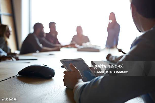 close-up of businessman holding tablet at meeting - flouté photos et images de collection