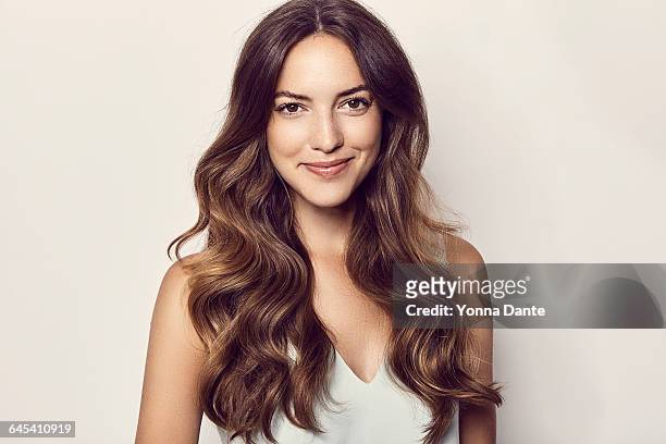 beautiful smiling woman with long brown wavy hair - capelli castani foto e immagini stock