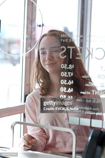 young girl buying a movie ticket at box office - taquilla lugar de comercio fotografías e imágenes de stock