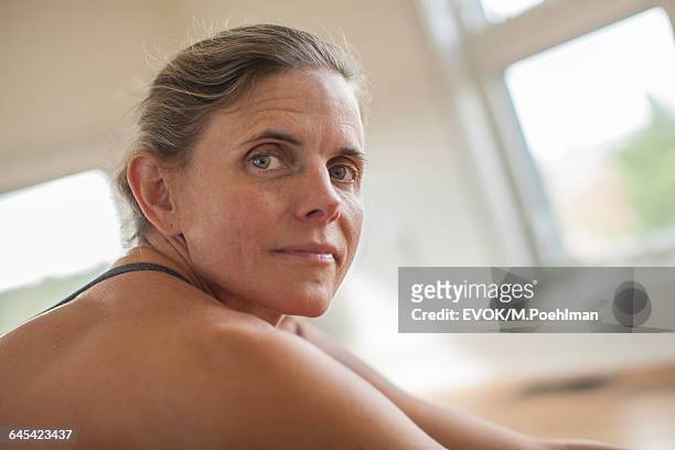 portrait of woman looking over shoulder during workout - shoulder detail ストックフォトと画像