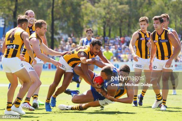 Braydon Preuss of the Kangaroos is tackled by Cyril Rioli and Marc Pittonet of the Hawks during the JLT Community Series AFL match between the North...